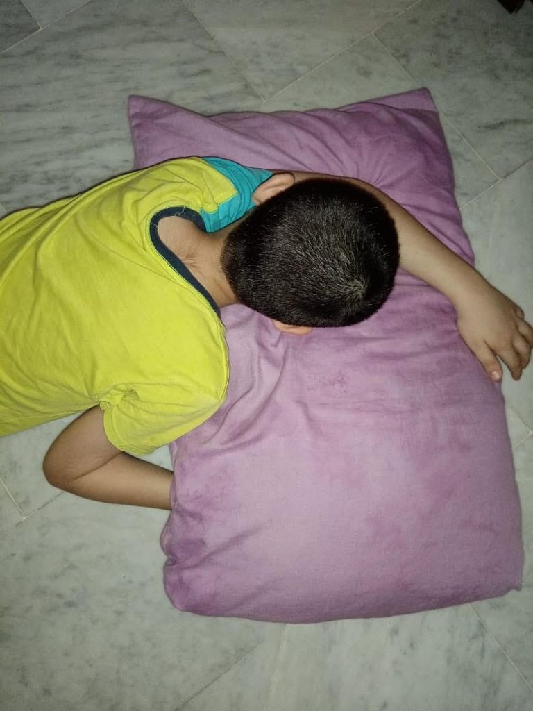 طفل ينام على البلاط أملا في عدم الشعور بالحرارة