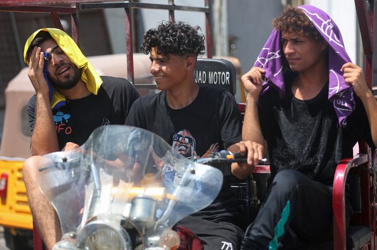 امرأة عراقية تستخدم المروحة الدوارة لمواجهة الحر وانقطاع الكهرباء