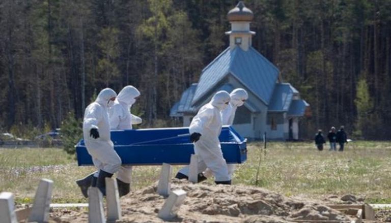 دفن أحد المتوفين بكورونا في روسيا- أرشيفية