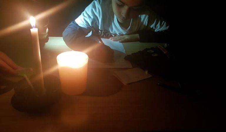 طالب لبناني يراجع دروسه على أضواء الشموع