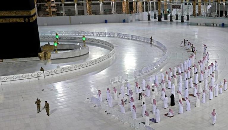 مجموعة من زوار بيتت الله يصلون أمام الكعبة