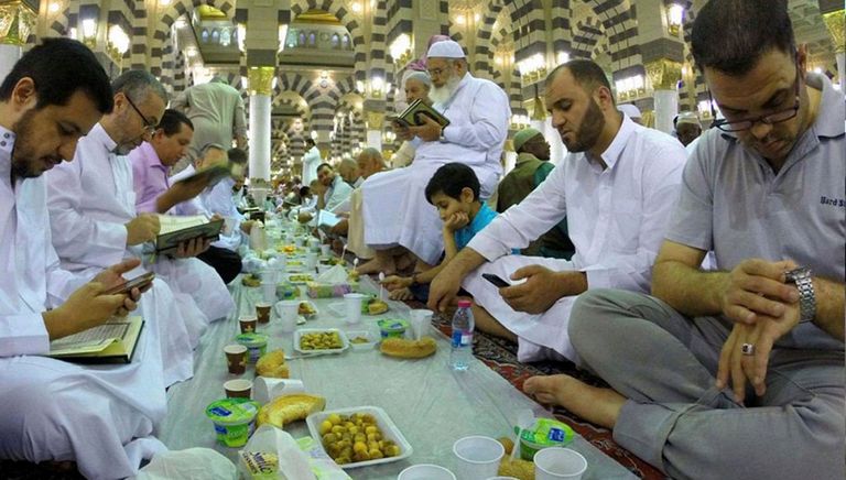 تناول الإفطار في الحج مجموعة من زوار بيتت الله يصلون أمام الكعبة