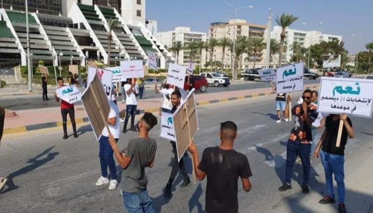 شباب يحملون لافتات ضمن مظاهرات تحديد المصير في ليبيا 