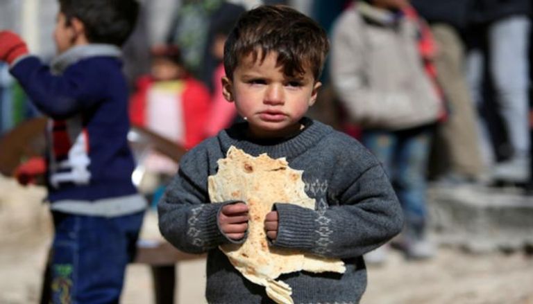 طفل سوري يحمل رغيفا من الخبز