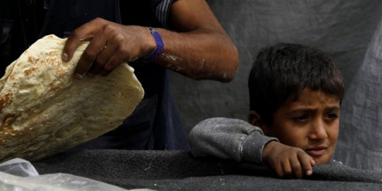 طفل سوري يحمل رغيفا من الخبز
