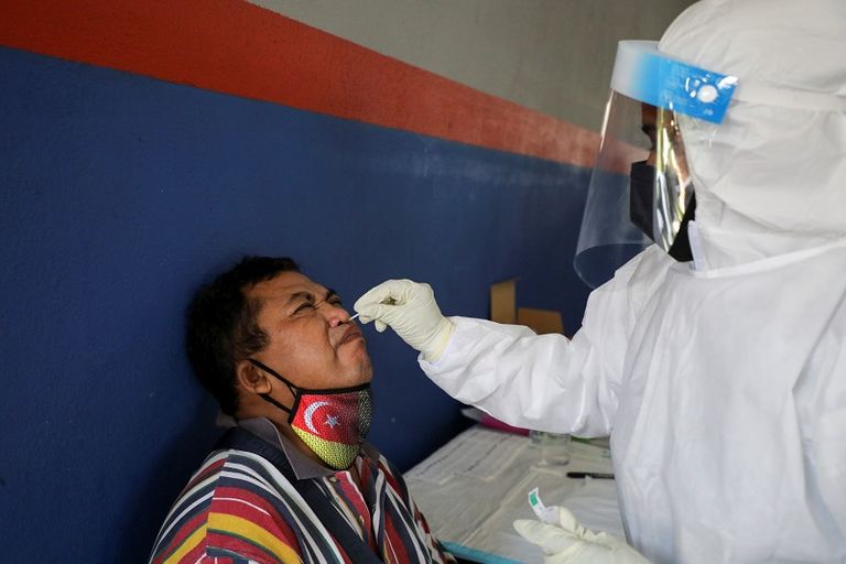 عامل صحي يأخذ مسحة من امرأة في ماليزيا