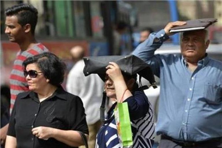 شابان مصريان يحميان أنفسهما من أشعة الشمس