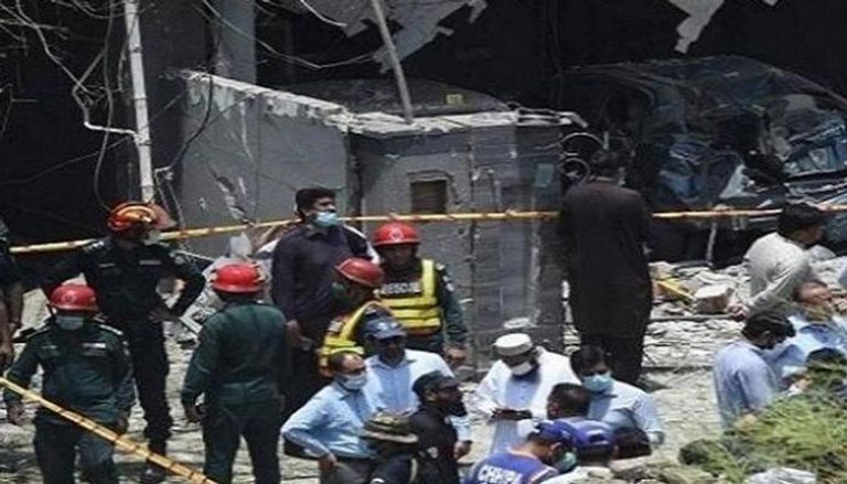 الشرطة وعمال الدفاع المدني في موقع انفجار الحافلة بباكستان