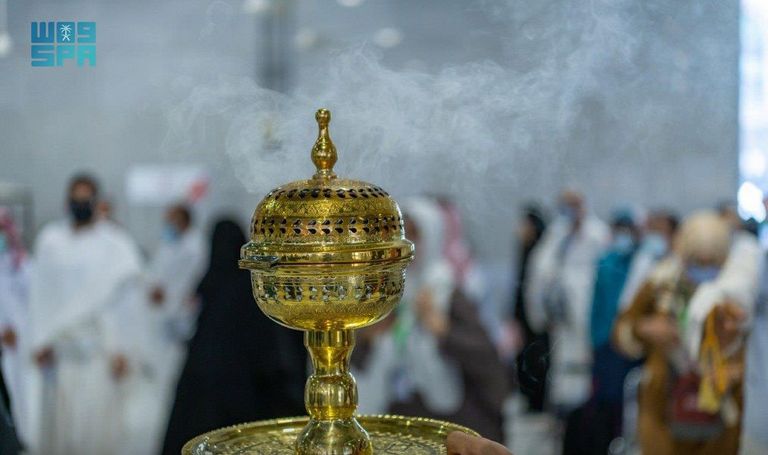 العاملون بالمسجد الحرام يتعطرون بالبخور في أول أيام العيد