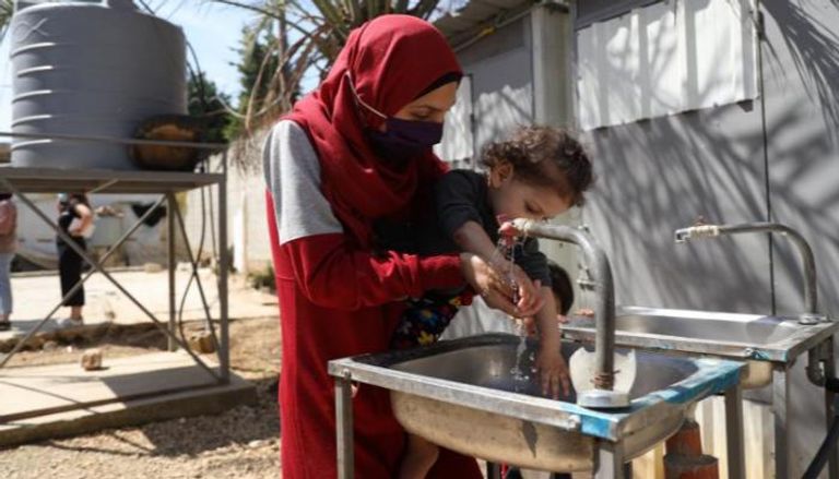 لبنانية تغسل يد طفلتها بالماء الذي قد لا يكون موجودا في الفترة القادمة