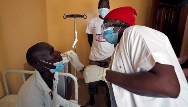 عاملة صحية تأخذ مسحة من شاب في السنغال
