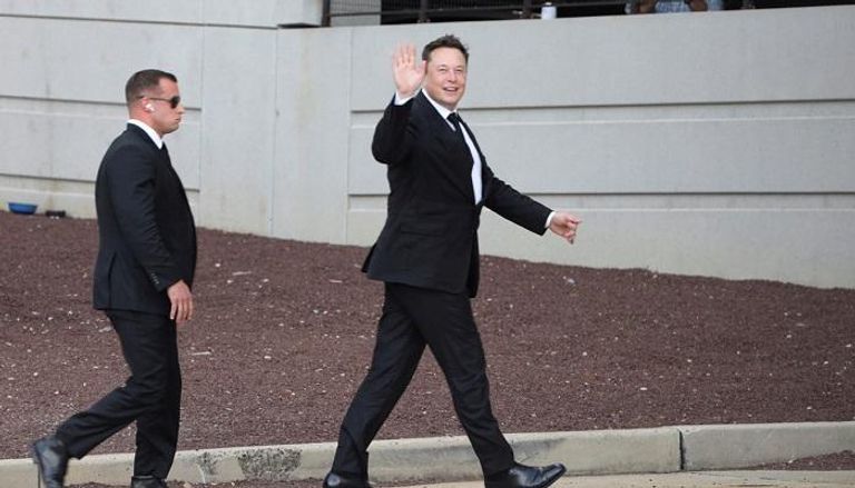 إيلون ماسك الرئيس التنفيذي لتسلا وشعار شركة أبل