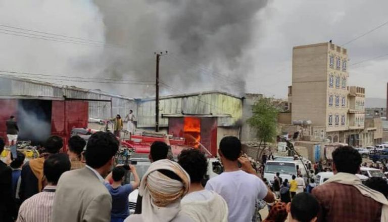 يمنيون يراقبون أحد الحرائق الغامضة التي استهدفت مستودعات تجارية في صنعاء