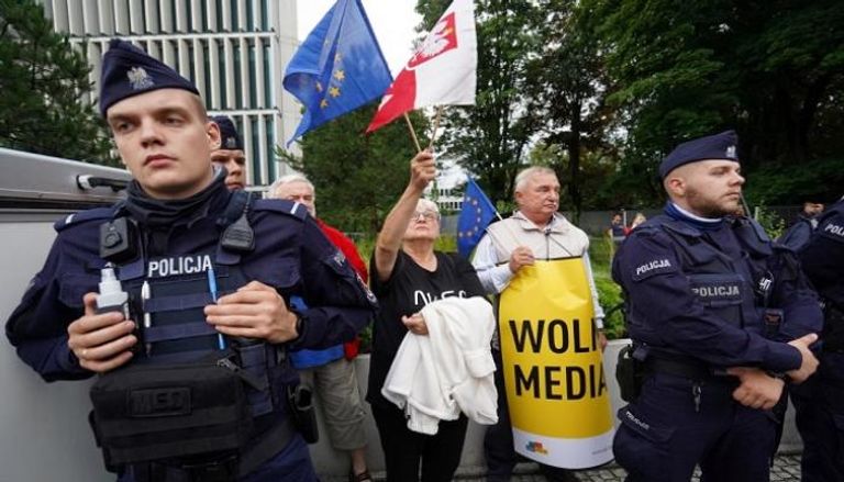 متظاهر يحمل العلمين الأوروبي والبولندي دفاعًا عن حرية الإعلام – أ.ف.ب
