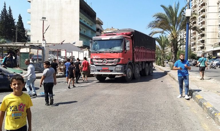 سيارة نقل تغلق الطريق احتجاجا على رفع دعم الوقود في لبنان الجيش اللبناني يحاول فتح الطريق المغلق أمام محطة وقود