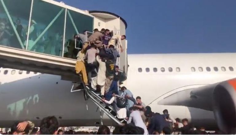 حشود من الأفغان يتسلقون طائرة في مطار كابول