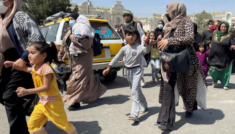 نساء أفغانيات يحاولن الهروب مع أطفالهن إلى مطار كابول 