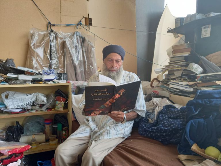 محمد المغربي وسط مسكنه وكتبه