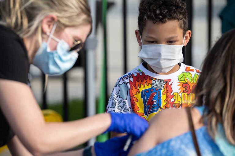 فتاة صغيرة بصحبة والدتها تحصل على التطعيم