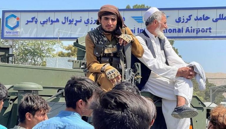 مسنّ أفغاني إلى جانب مقاتل من طالبان- رويترز