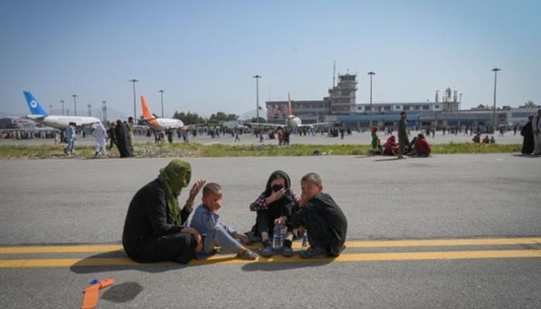 أسرة أفغانية تحاول الهروب عبر مطار كابول - أ.ف.ب