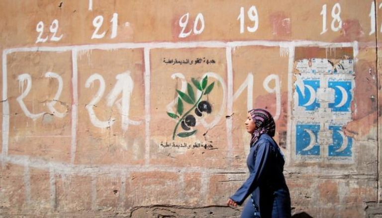 سيد مغربية أمام جدار يحمل دعاية انتخابية - أرشيفية