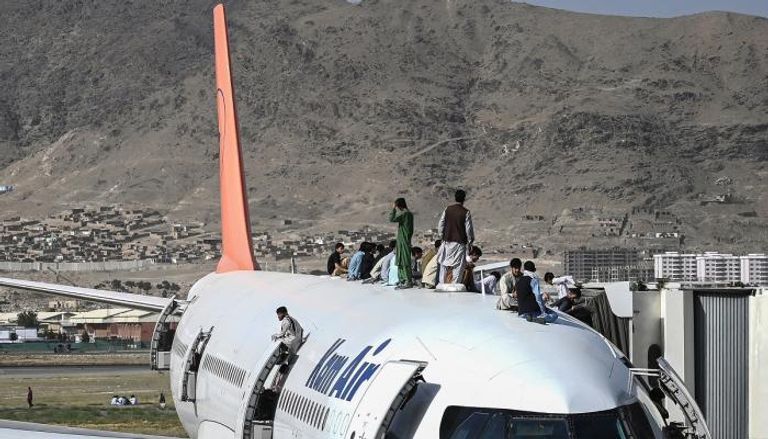 أفغان يعتلون إحدى الطائرات في مطار كابول