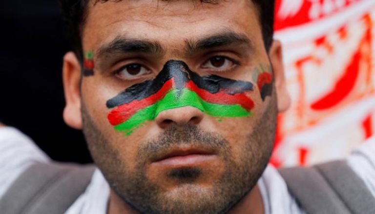 متظاهر أفغاني رسم علم بلاده على وجهه