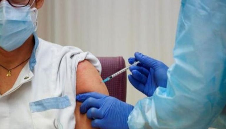 شاب يتلقى تطعيما ضد كورونا في الإمارات