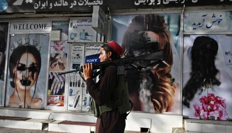عنصر من طالبان أمام واجهة مشوهة لأحد محلات كابول