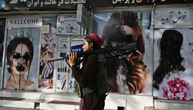 عنصر من طالبان أمام واجهة مشوهة لأحد محلات كابول