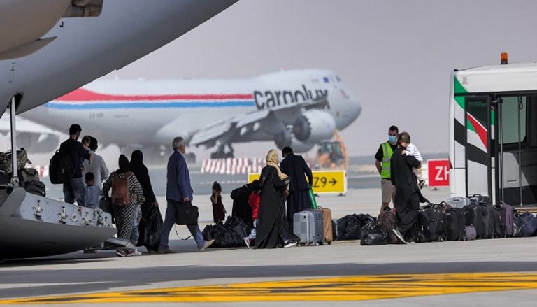 أفغان في مطار آل مكتوم الدولي ينتظرون طائرات تقلهم لبريطانيا- أ.ف.ب