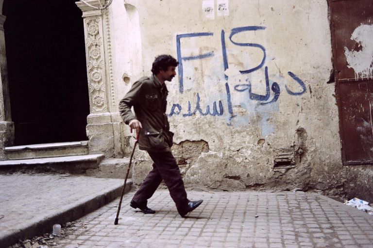 شعار الجبهة الإرهابية للانقاذ الإخوانية سنوات التسعينيات بالجزائر جزائرية تبكي.. ذبح الإرهابيون عائلتها بسنوات التسعينيات - أرشيفية