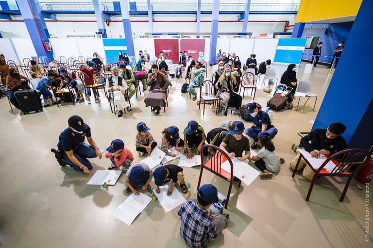 إحدى الشرطيات الإيطاليات ترسم مع طفلة أفغانية