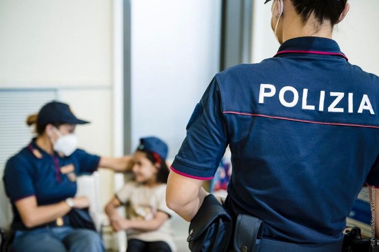 إحدى الشرطيات الإيطاليات ترسم مع طفلة أفغانية