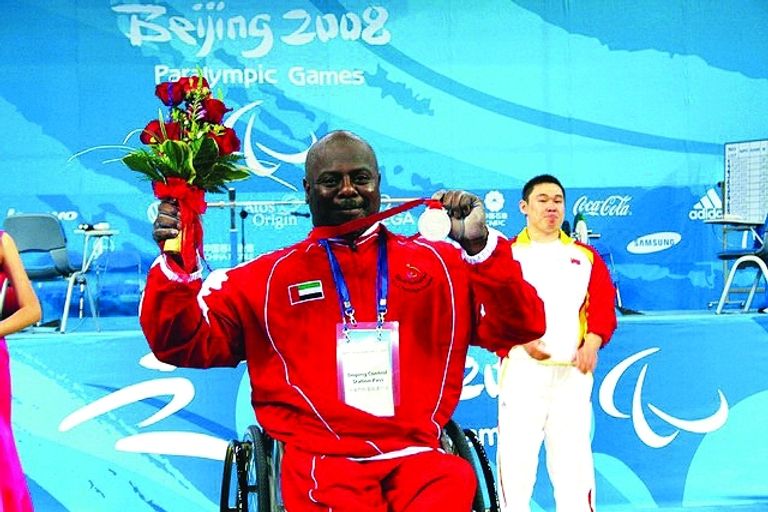 البطل الإماراتي محمد خميس خلف البطل محمد القايد يحمل علم الإمارات في بارالمبياد طوكيو