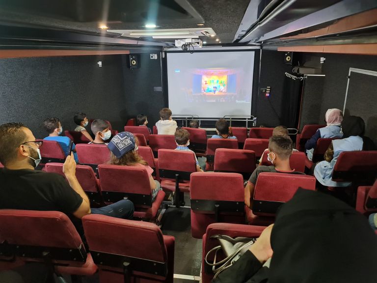 أطفال يستعدون لمشاهدة عرض سينمائي في باص السينما