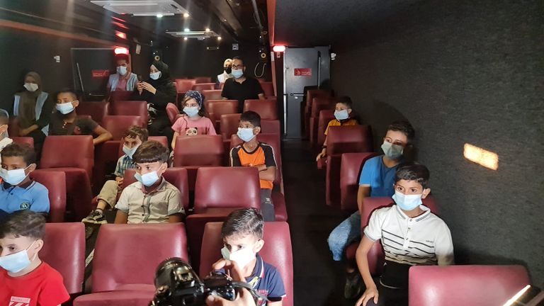 أطفال يستعدون لمشاهدة عرض سينمائي في باص السينما