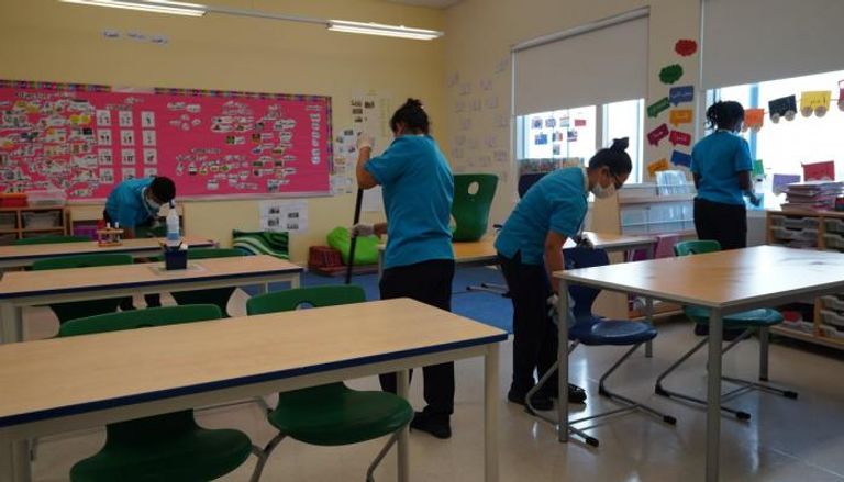 مسؤولات النظافة يعقمن صفا دراسيا بإحدى مدارس الإمارات