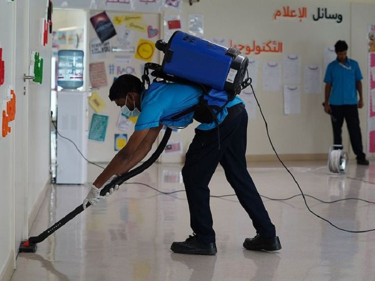 مسؤولات النظافة يعقمن صفا دراسيا بإحدى مدارس الإمارات