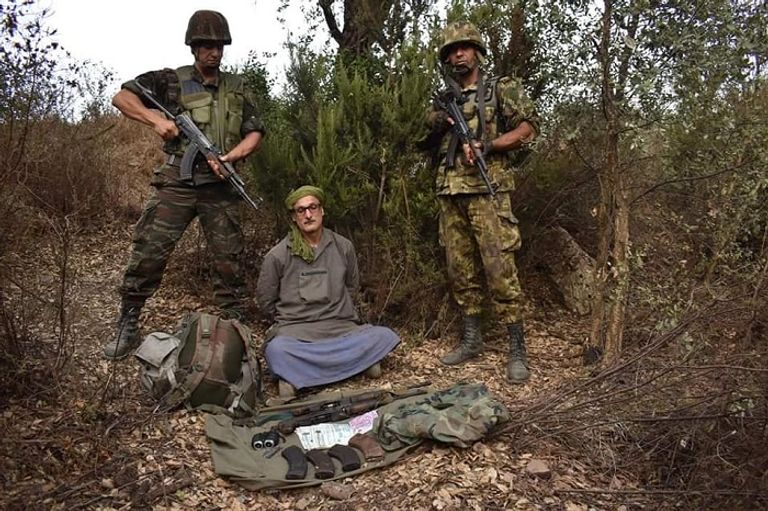 الإرهابي لعور يتوسط جنودا بالجيش الجزائري بعد القبض عليه الإرهابي