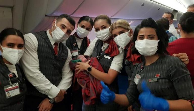 طاقم الطائرة التركية مع المولود الأفغاني الجديد
