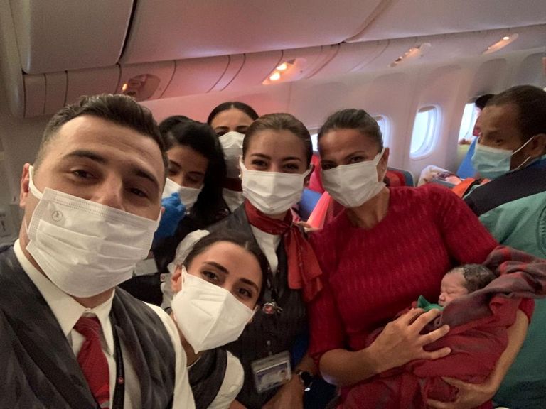 طاقم الطائرة التركية مع المولود الأفغاني الجديد