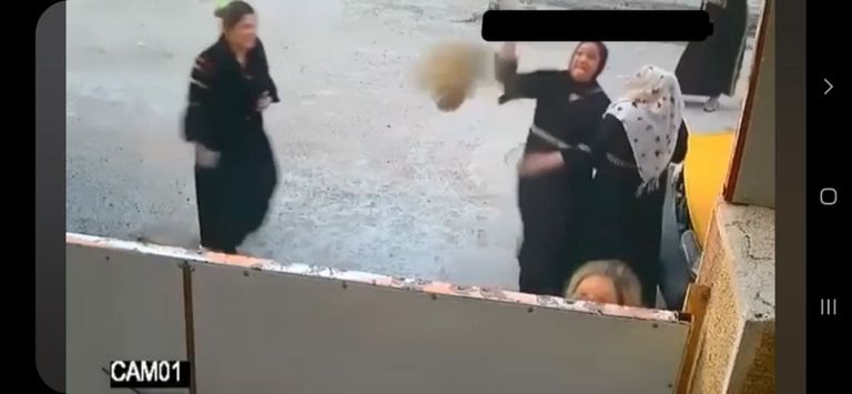صورة ملتقطة من مقطع فيديو لنساء يهاجمن أحد المنازل بالحجارة