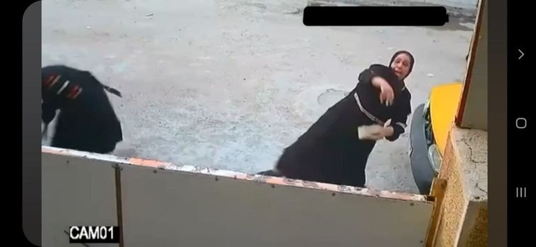 صورة ملتقطة من مقطع فيديو لنساء يهاجمن أحد المنازل بالحجارة