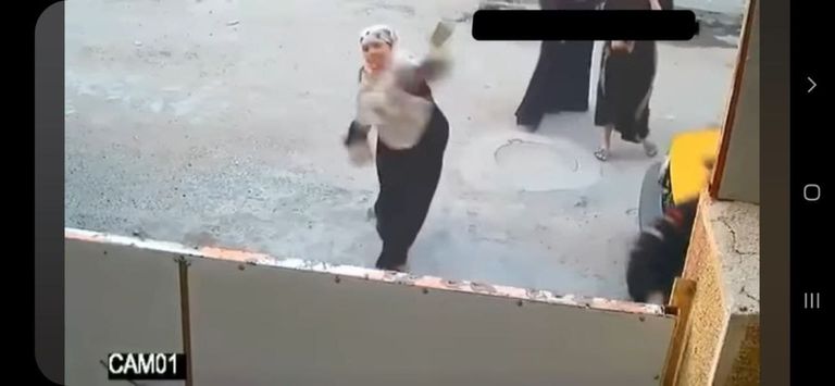 صورة ملتقطة من مقطع فيديو لنساء يهاجمن أحد المنازل بالحجارة