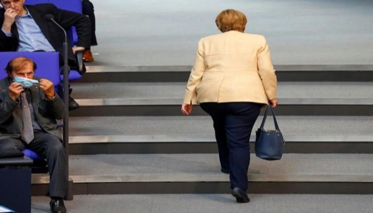 ميركل لحظة مغادرتها البرلمان الألماني - رويترز
