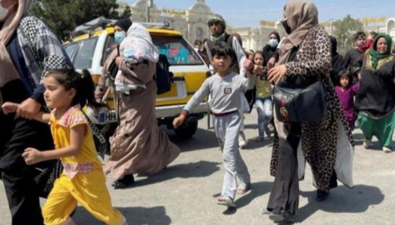 نساء أفغانيات يحاولن الهروب مع أطفالهن إلى مطار كابول- أرشيفية