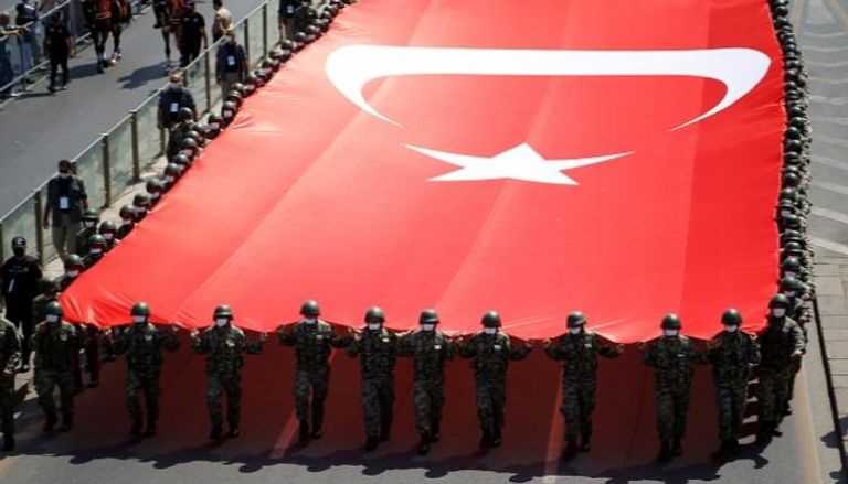 جنود أتراك يحملون علم بلادهم في استعراض عسكري
