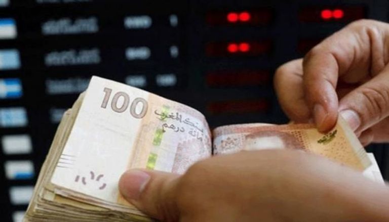 موظف بأحد البنوك يقوم بفرز عملات ورقية من الدرهم المغربي
